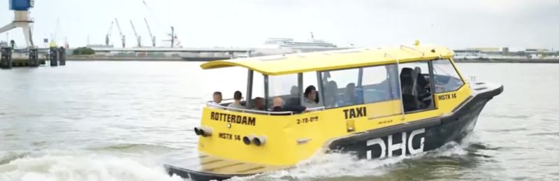 Gele watertaxi vaart over rivier.